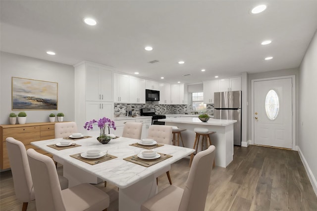 dining space with hardwood / wood-style floors and sink