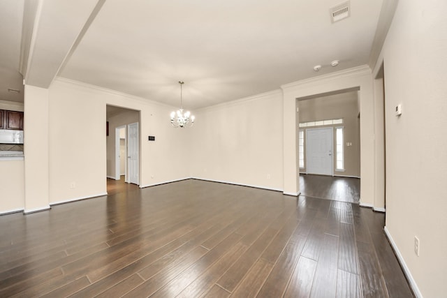 spare room featuring crown molding, a notable chandelier, and dark hardwood / wood-style flooring