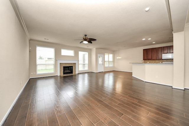 unfurnished living room with ceiling fan, dark hardwood / wood-style floors, and ornamental molding