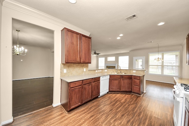 kitchen with white appliances, crown molding, dark hardwood / wood-style floors, and kitchen peninsula