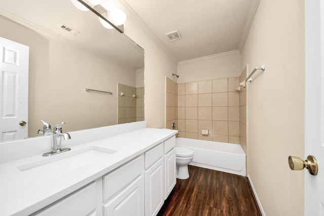 full bathroom featuring wood-type flooring, vanity, tiled shower / bath, toilet, and ornamental molding