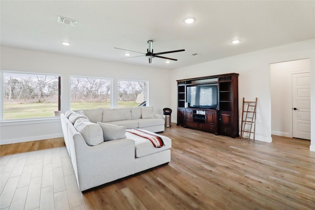 living area featuring light wood-style flooring, visible vents, baseboards, and recessed lighting