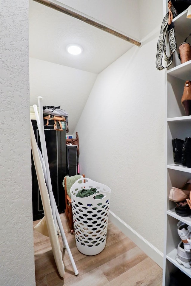 spacious closet featuring vaulted ceiling and wood finished floors