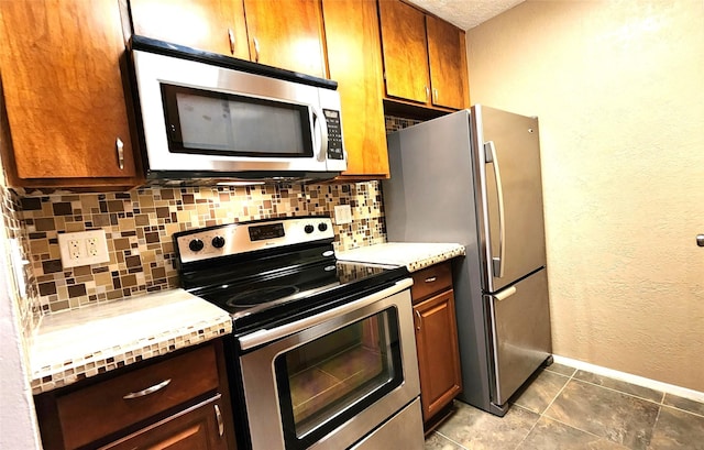 kitchen featuring tile patterned floors, stainless steel appliances, and decorative backsplash