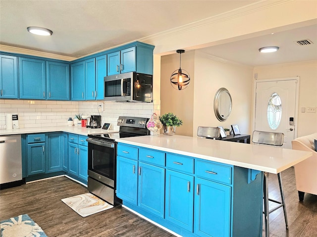 kitchen featuring a peninsula, a breakfast bar, hanging light fixtures, appliances with stainless steel finishes, and light countertops