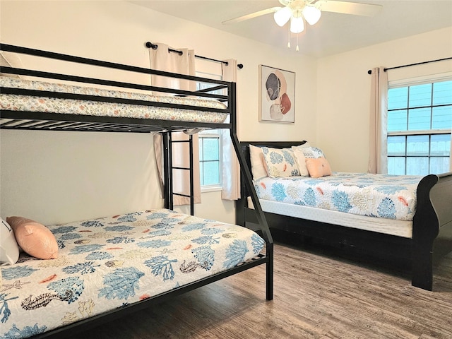 bedroom featuring multiple windows, a ceiling fan, and wood finished floors