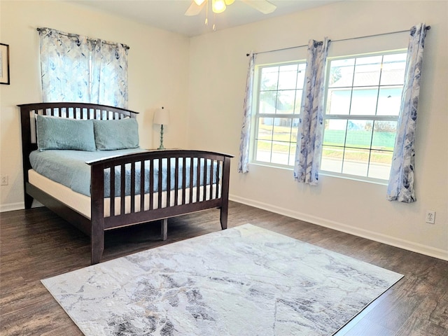 bedroom with ceiling fan, baseboards, and dark wood finished floors