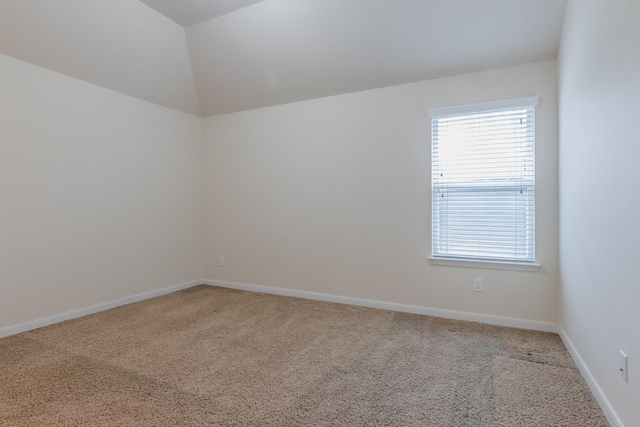 unfurnished room with light carpet and lofted ceiling