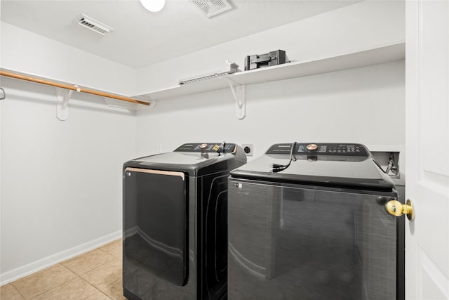 washroom with washing machine and dryer and light tile patterned floors