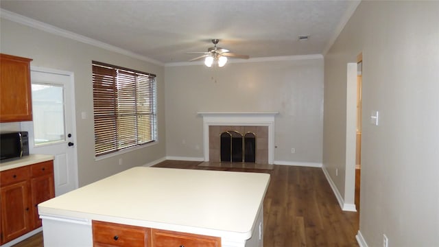 kitchen with a center island, light countertops, brown cabinetry, open floor plan, and black microwave