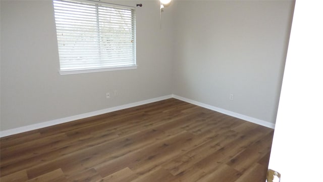 unfurnished room with dark wood-type flooring