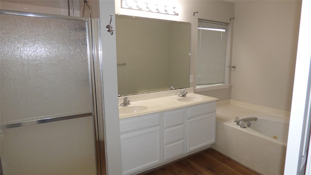 bathroom with hardwood / wood-style flooring, separate shower and tub, and vanity