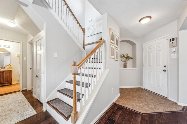 foyer entrance featuring a textured ceiling and dark wood-type flooring