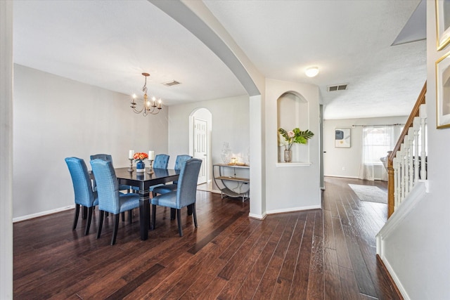 dining room with dark hardwood / wood-style flooring and a notable chandelier