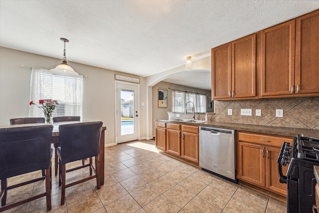 kitchen featuring sink, gas stove, dishwasher, decorative light fixtures, and tasteful backsplash