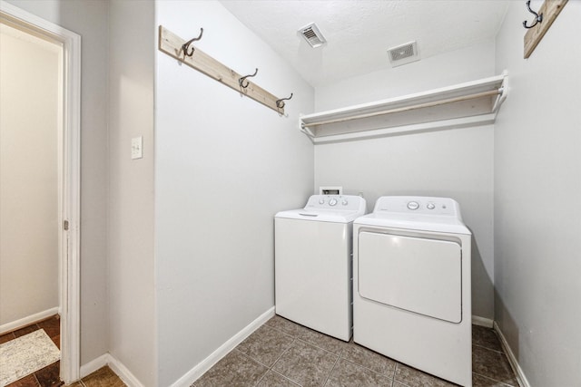 laundry room with independent washer and dryer and a textured ceiling