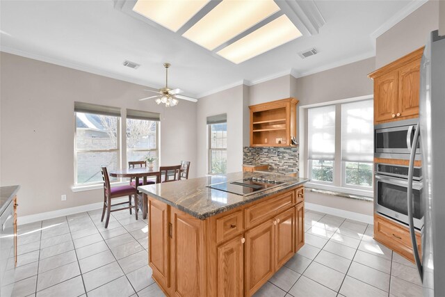2715 Penmere Ct, Kingwood, TX 77345 - kitchen featuring stainless steel appliances, light tile patterned floors, a kitchen island, crown molding, and tasteful backsplash