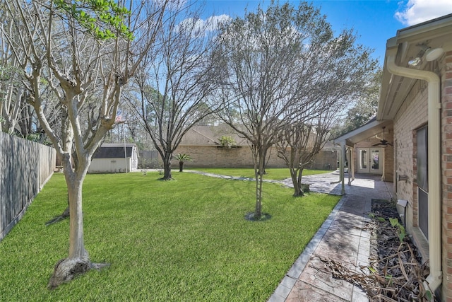 view of yard with ceiling fan and a patio