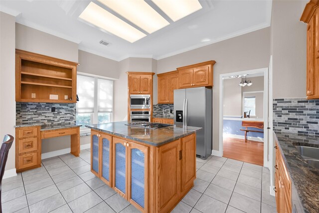 kitchen with appliances with stainless steel finishes, light tile patterned floors, backsplash, a center island, and dark stone countertops