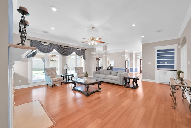 living room featuring light hardwood / wood-style floors, ceiling fan, built in features, and ornamental molding