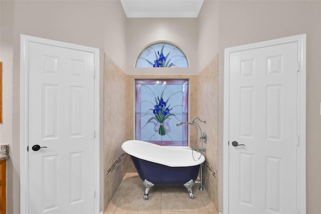 bathroom with a freestanding tub, vanity, and tile patterned floors