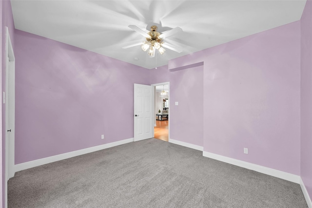 carpeted spare room with ceiling fan