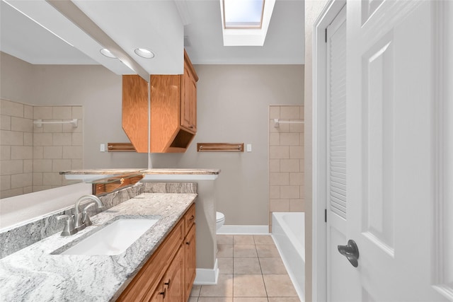 full bathroom featuring tile patterned flooring, toilet, a skylight, a shower, and vanity