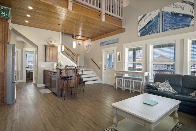 living room with stairs, dark wood-type flooring, a high ceiling, and wood ceiling