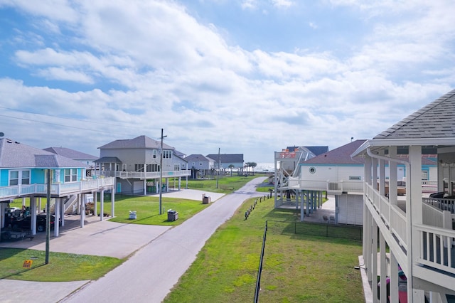 surrounding community with a carport, a residential view, concrete driveway, and a lawn