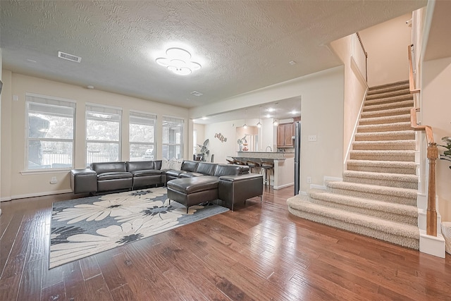 living room with a textured ceiling and hardwood / wood-style flooring