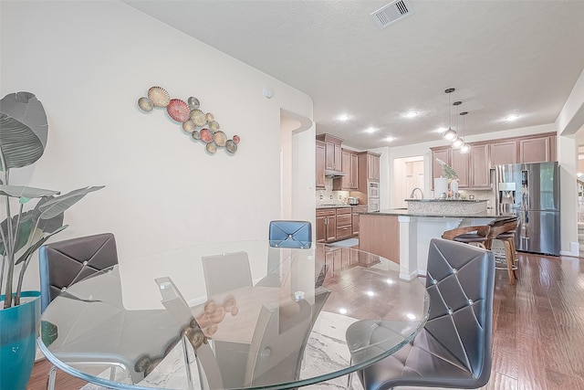 dining area with a textured ceiling and dark hardwood / wood-style floors