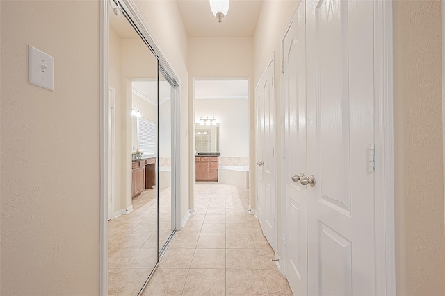 corridor featuring ornamental molding and light tile patterned flooring