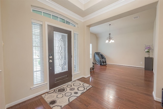 entryway with a notable chandelier, ornamental molding, wood-type flooring, and a healthy amount of sunlight