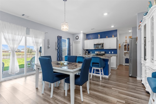 dining area with recessed lighting, visible vents, and light wood-style flooring