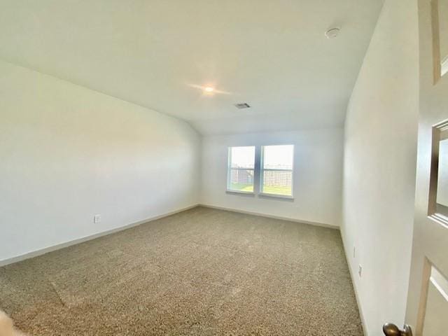 carpeted spare room with lofted ceiling