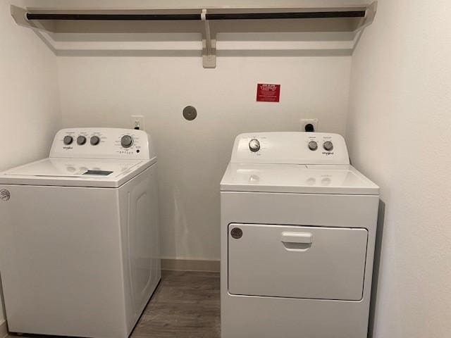 washroom featuring washing machine and dryer and dark wood-type flooring