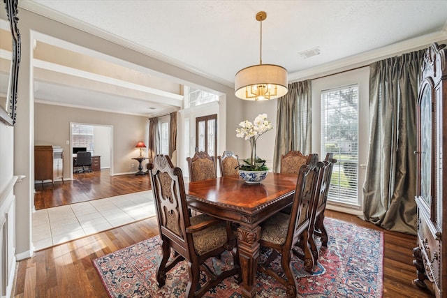 dining area featuring crown molding, a wealth of natural light, and wood-type flooring