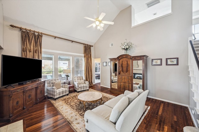 living room with dark hardwood / wood-style flooring, ceiling fan, and high vaulted ceiling