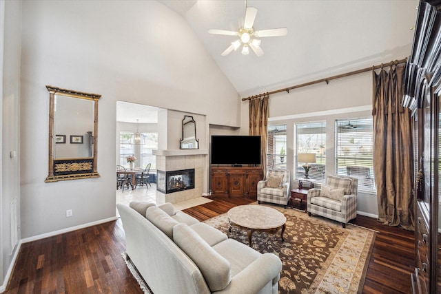 living room with a fireplace, high vaulted ceiling, dark hardwood / wood-style flooring, and plenty of natural light