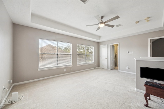 carpeted living room with ceiling fan, a raised ceiling, and a textured ceiling