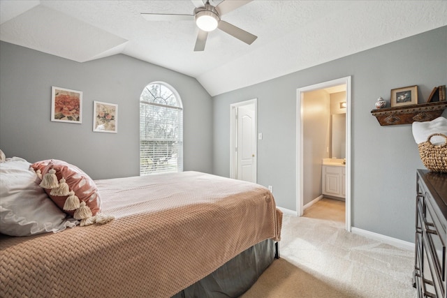 carpeted bedroom featuring a textured ceiling, lofted ceiling, ensuite bathroom, and ceiling fan