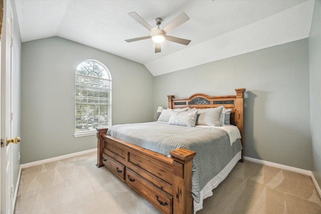 bedroom with ceiling fan, vaulted ceiling, and light colored carpet