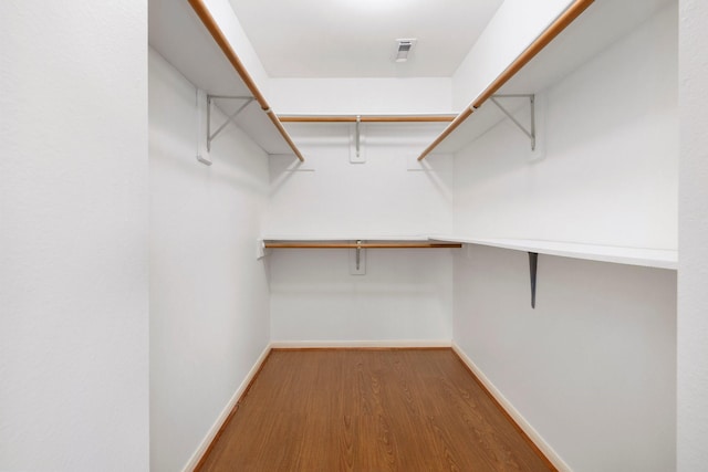 walk in closet with hardwood / wood-style floors