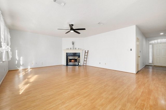 unfurnished living room featuring light wood-type flooring, ceiling fan, and a fireplace