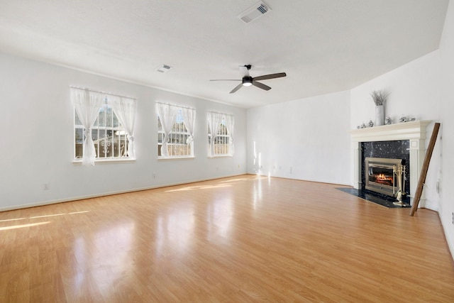 unfurnished living room featuring light wood-type flooring, ceiling fan, and a fireplace