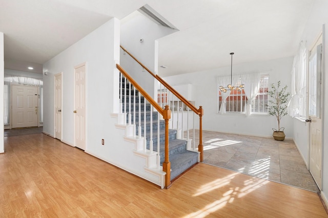 staircase featuring hardwood / wood-style flooring and a notable chandelier