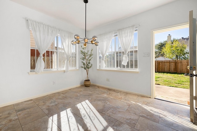 unfurnished dining area featuring an inviting chandelier and a wealth of natural light