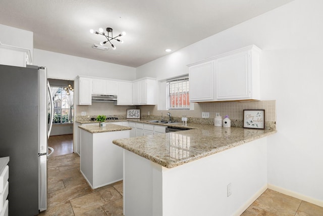 kitchen featuring white cabinetry, kitchen peninsula, appliances with stainless steel finishes, and tasteful backsplash