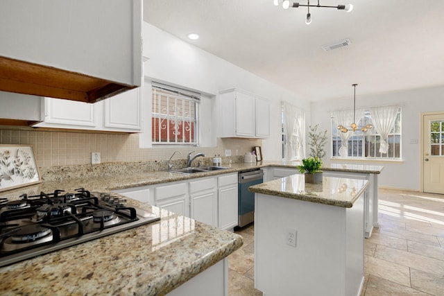 kitchen featuring appliances with stainless steel finishes, a kitchen island, sink, and white cabinetry