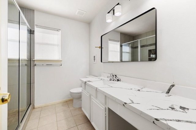 bathroom featuring toilet, vanity, tile patterned flooring, and a shower with door